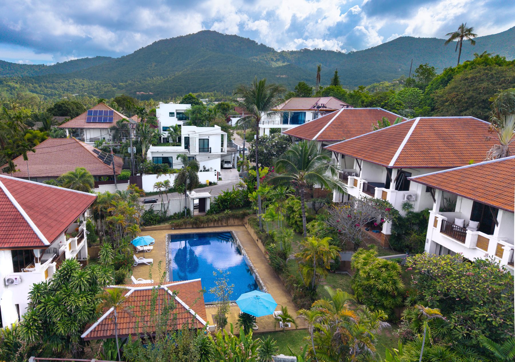 Maenam Hills villas and pool on the hillside above Mae Nam, Koh Samui, with the mountains behind