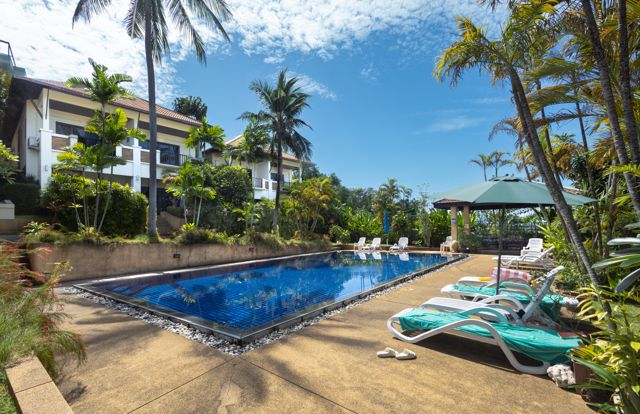 Pool deck with loungers and palms